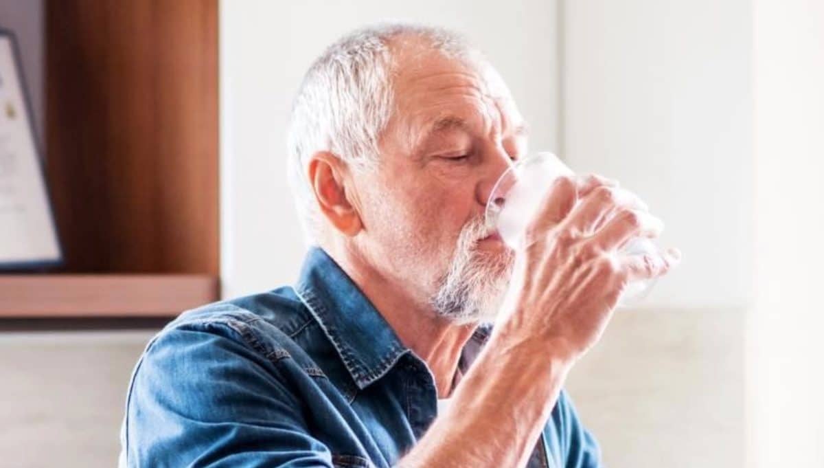 Un homme en train de boire un verre d'eau