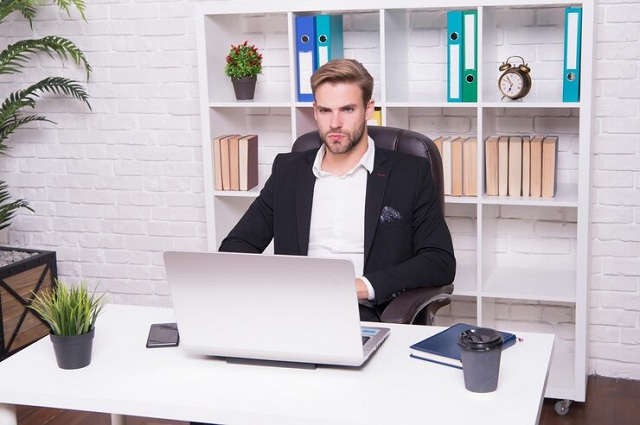 Un homme assis devant son ordinateur portable